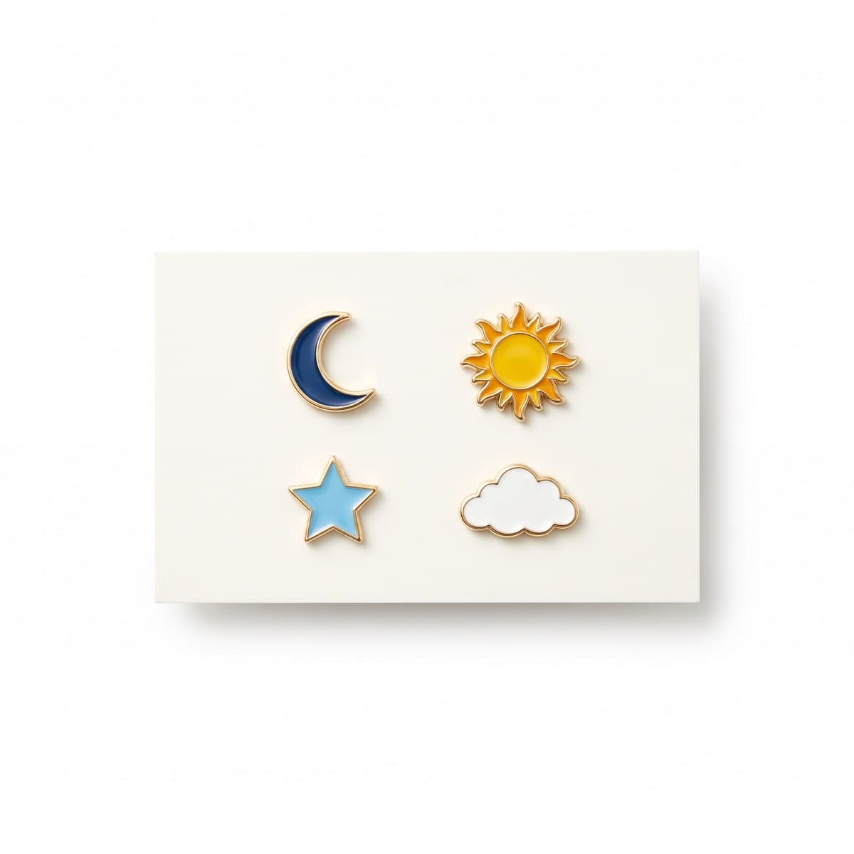 Four hard-enamel pins, a moon, sun, star and cloud, on a printed backing card